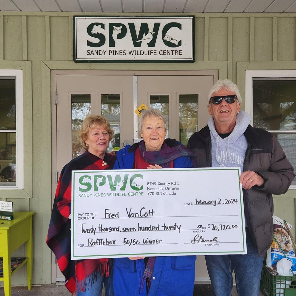 Sandy Pines Wildlife Center in South East Ontario awarding three seniors a cheque for $20,720 in front of their offices